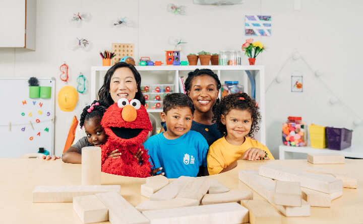 Priscilla Chan poses with Elmo, a teacher and school children