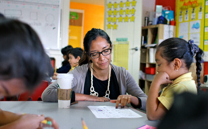 A Chan Zuckerberg Initiative employee works with a young student inside the classroom