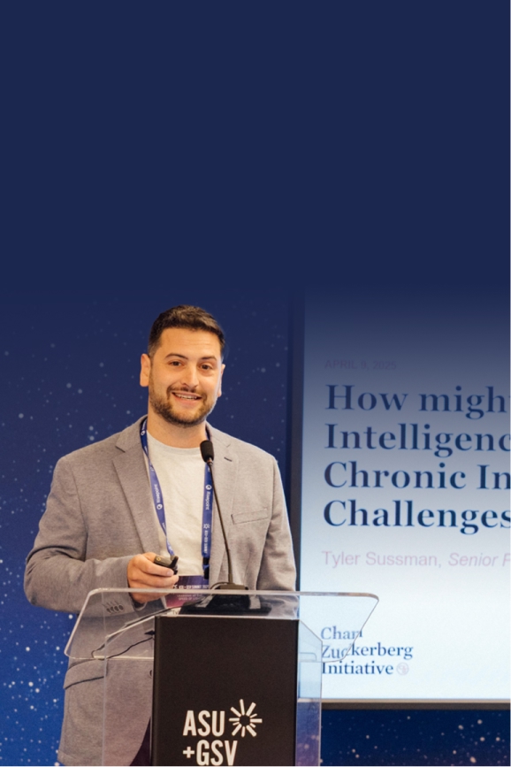 Tyler Sussman, senior program officer at the Chan Zuckerberg Initiative, presents at the ASU+GSV Summit. He stands at a podium next to a screen displaying the title of his talk: “How Might Artificial Intelligence Address Chronic Instructional Challenges.”